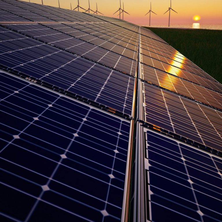 Solarparks bei Abenddämmerung Perspektivische Nahaufnahme von Photovoltaik-Modulen auf einer Freifläche im warmen Licht des Sonnenuntergangs mit Windrädern
